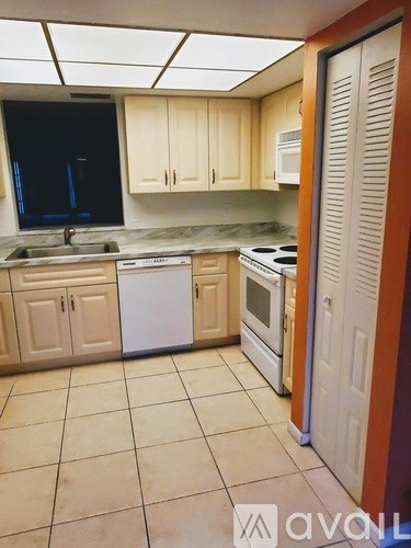 A kitchen with wooden cabinets and a white dishwasher.