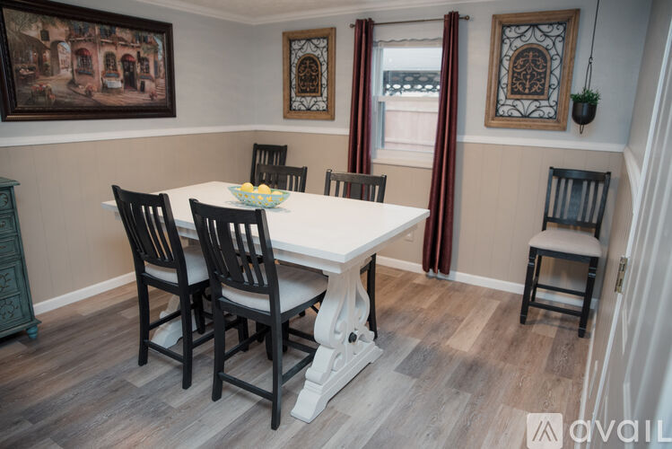 A dining room with a white table and chairs.