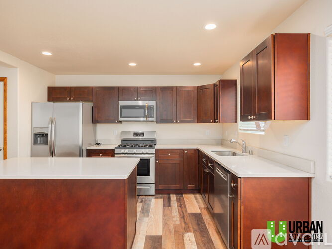 A kitchen with wooden cabinets and a white counter top.