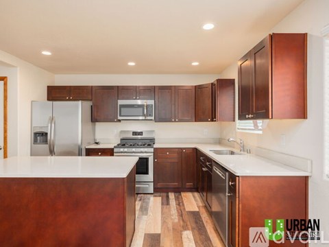 A kitchen with wooden cabinets and a white counter top.