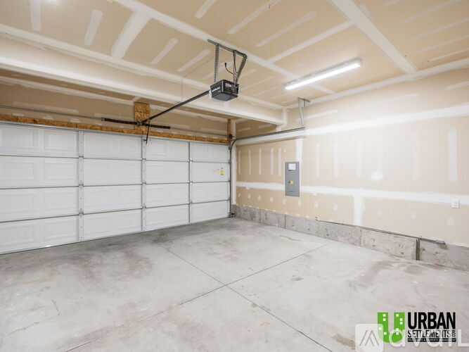 A spacious garage with a white door and a concrete floor.