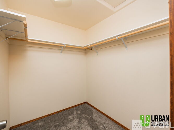 A room with a grey carpet and a white wall.
