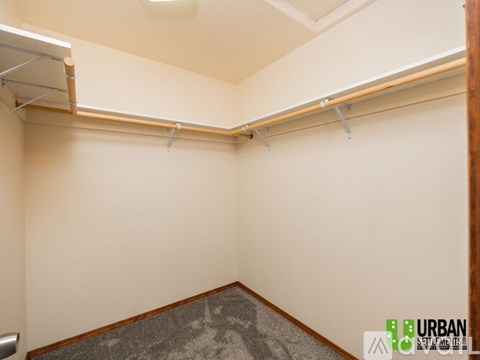 A room with a grey carpet and a white wall.