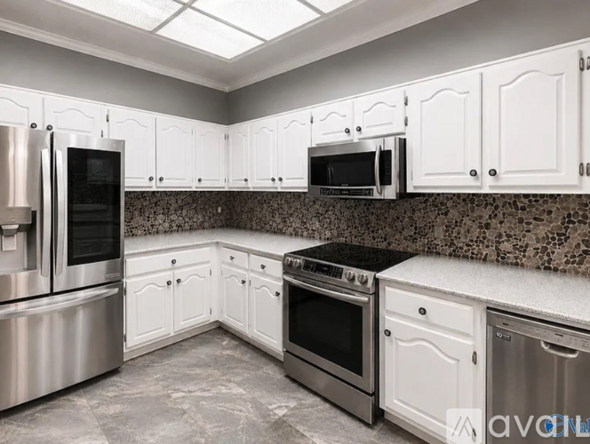 A kitchen with white cabinets and stainless steel appliances.