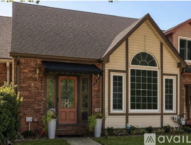 A house with a brown door and a window with a white frame.