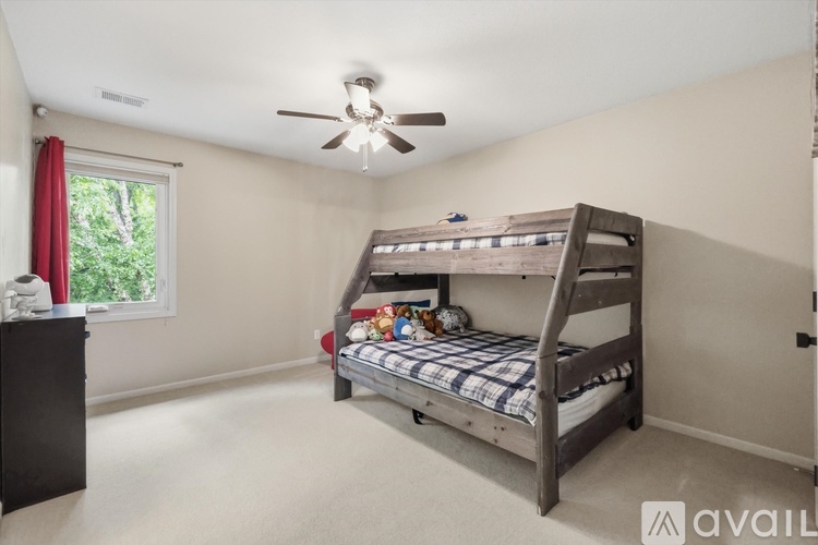 A bedroom with a bunk bed and a ceiling fan.