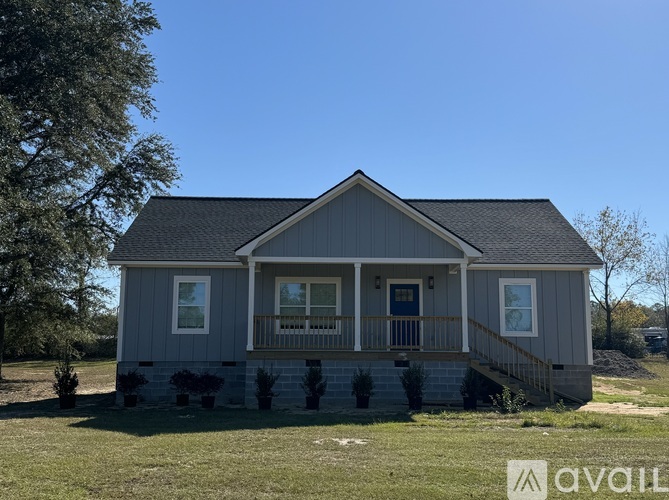 A house with a grey exterior and a balcony is for sale.