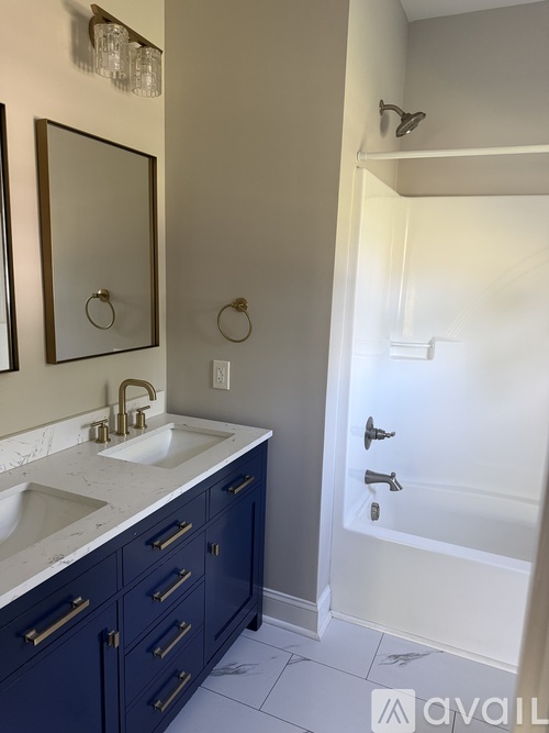 A bathroom with a sink, mirror, and shower.
