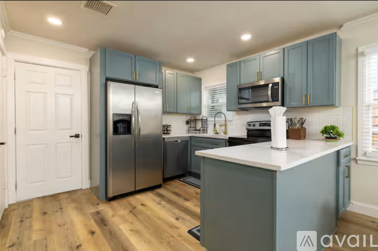 A kitchen with a refrigerator, microwave, and oven.