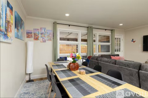 A dining room with a long table and chairs.