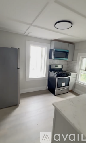A kitchen with a microwave above the stove and a refrigerator to the left.