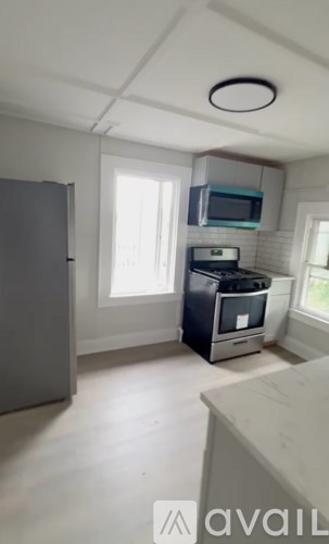 A kitchen with a microwave above the stove and a refrigerator to the left.