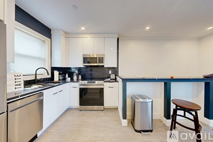 A kitchen with a stainless steel dishwasher and a white oven.