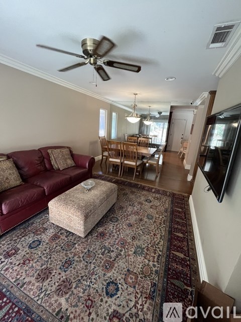 A living room with a red couch and a rug with a floral pattern.