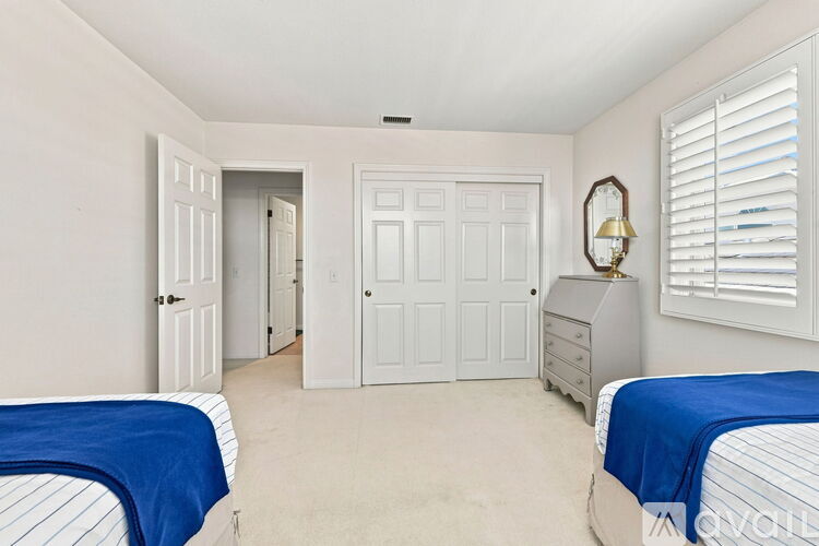 A bedroom with two beds and a dresser.