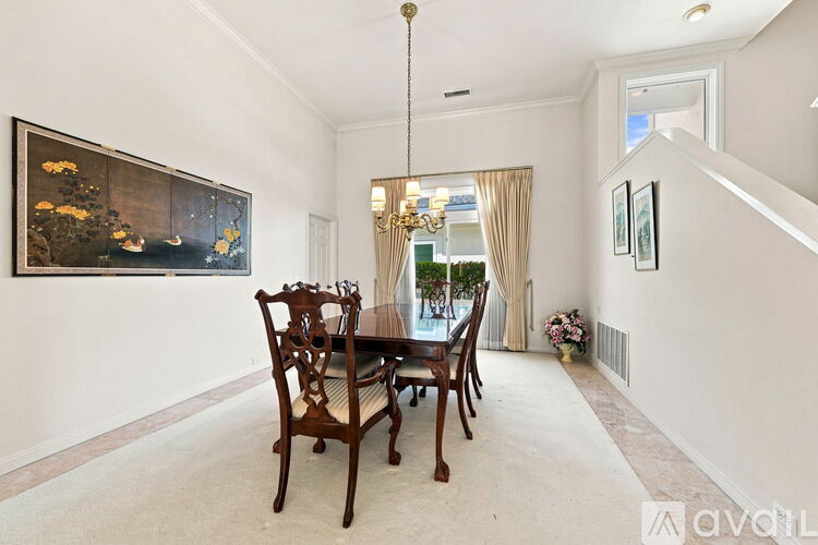 A dining room with a table and chairs.