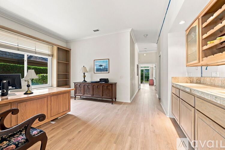 A well-lit, spacious room with wooden floors and furniture.