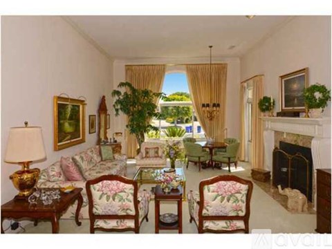 A living room with a fireplace and a painting on the wall.