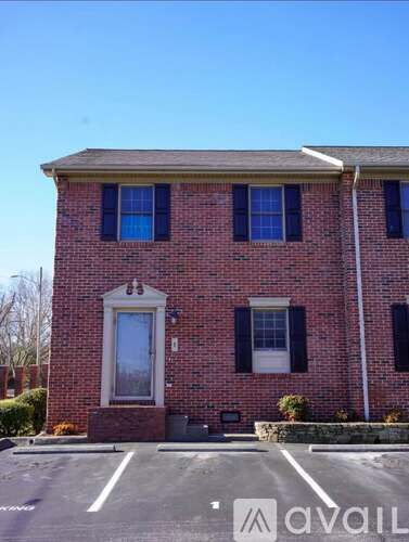 A red brick house with a white door and windows.