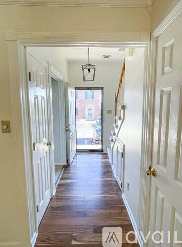 A hallway with white doors and a light hanging from the ceiling.