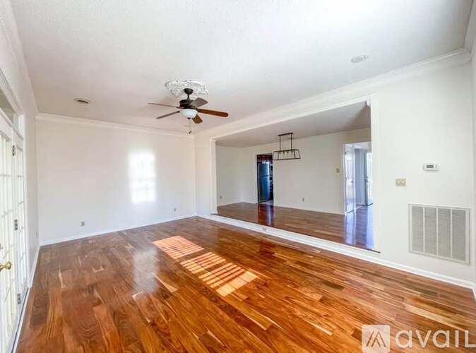 A room with wooden floors and a ceiling fan.