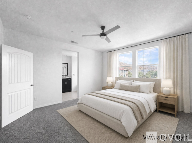 A bedroom with a large bed and a ceiling fan.
