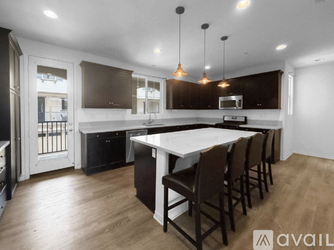 A modern kitchen with dark brown cabinets and a white island.