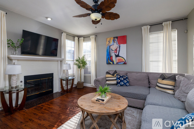A living room with a grey couch, a wooden coffee table, and a fireplace.
