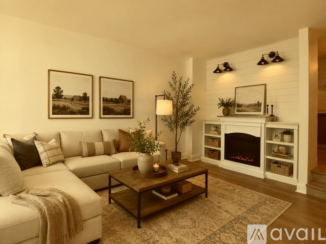A living room with a white couch, a coffee table, and a fireplace.