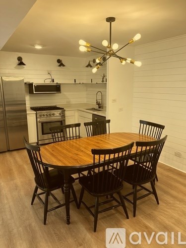 A modern kitchen with a wooden table and chairs.