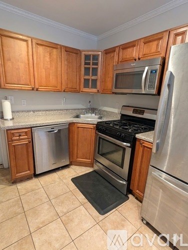 A kitchen with wooden cabinets and stainless steel appliances.