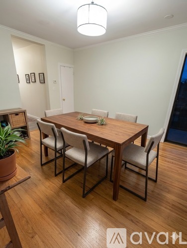 A dining room with a wooden table and chairs.