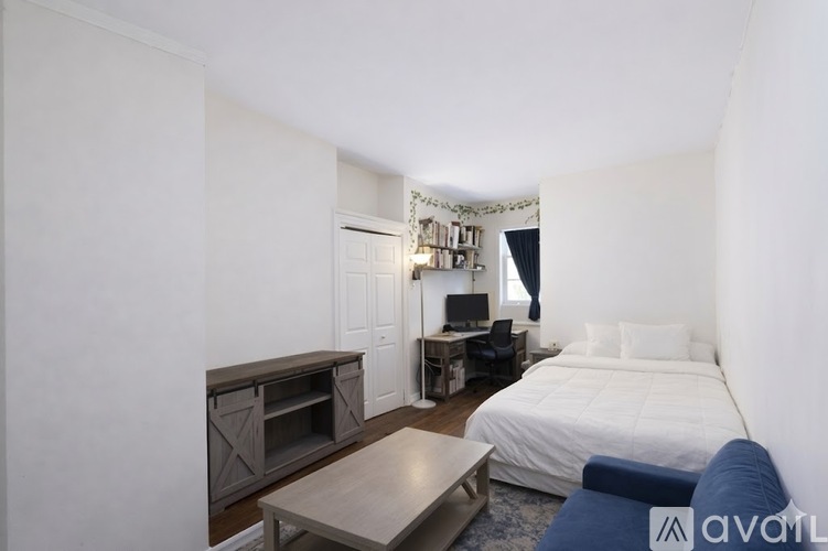 A bedroom with a bed, desk, and chair.