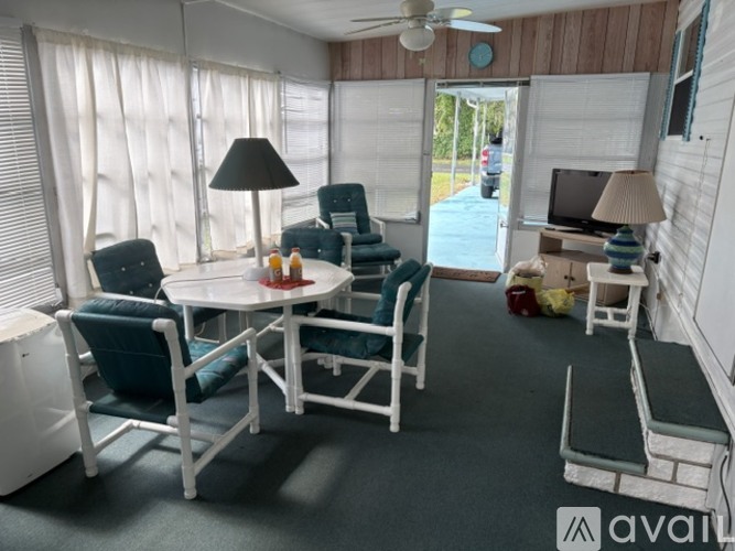 A living room with a white table and chairs.