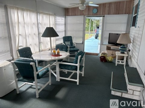 A living room with a white table and chairs.