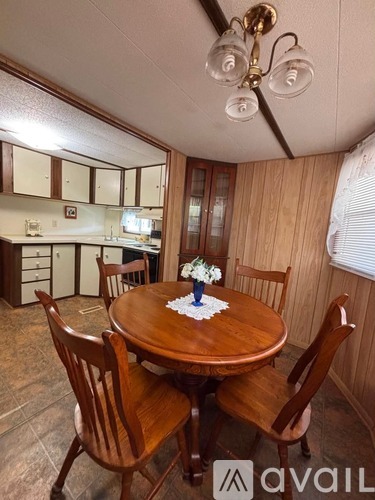 A dining room with a wooden table and chairs.