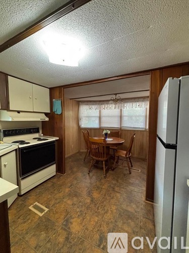 A kitchen with a table and chairs in front of a window.