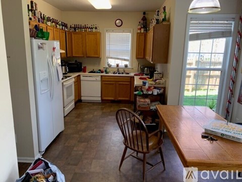 A kitchen with wooden cabinets and a white refrigerator.