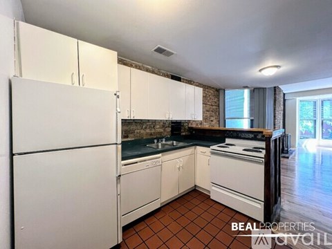 A kitchen with white appliances and a stone backsplash.