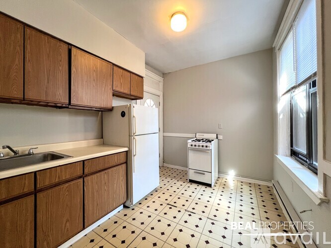 A kitchen with wooden cabinets and a white fridge.