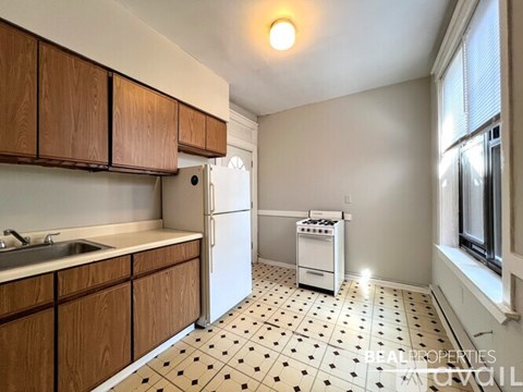 A kitchen with wooden cabinets and a white fridge.