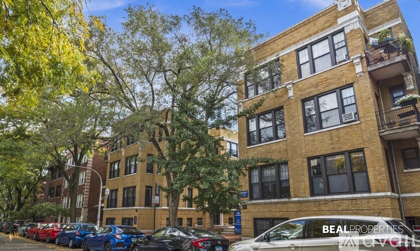 A row of cars parked in front of a building with the words "BEAL PROPERTIES" on the side.
