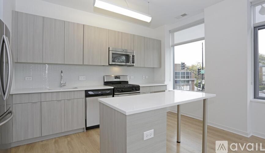 A kitchen with a white countertop and grey cabinets.