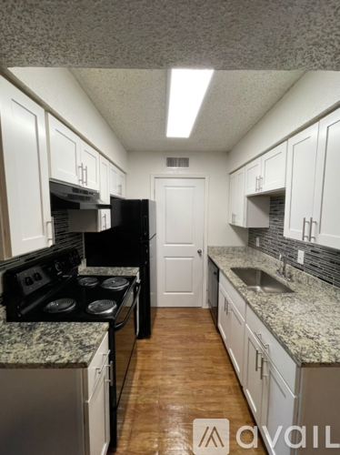 A kitchen with white cabinets and a granite countertop.