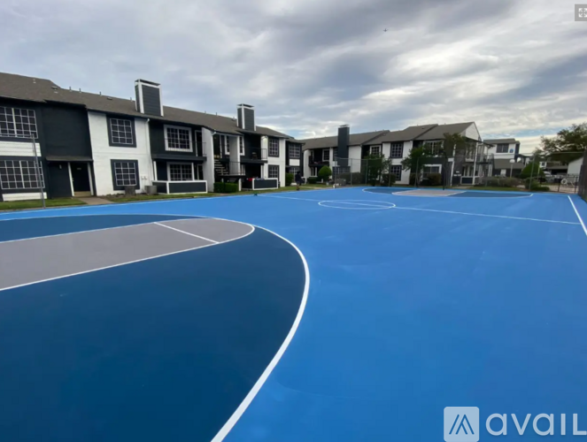 A basketball court is located in front of apartment buildings.