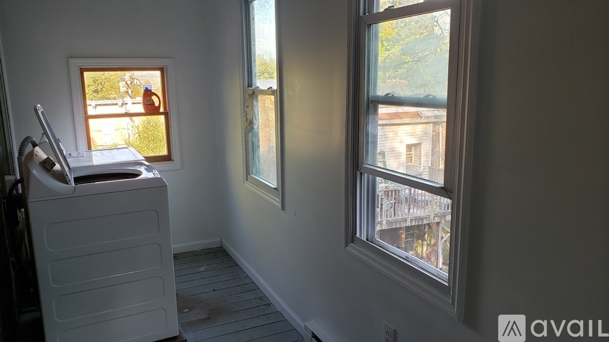 A room with a window showing a view of a building outside.