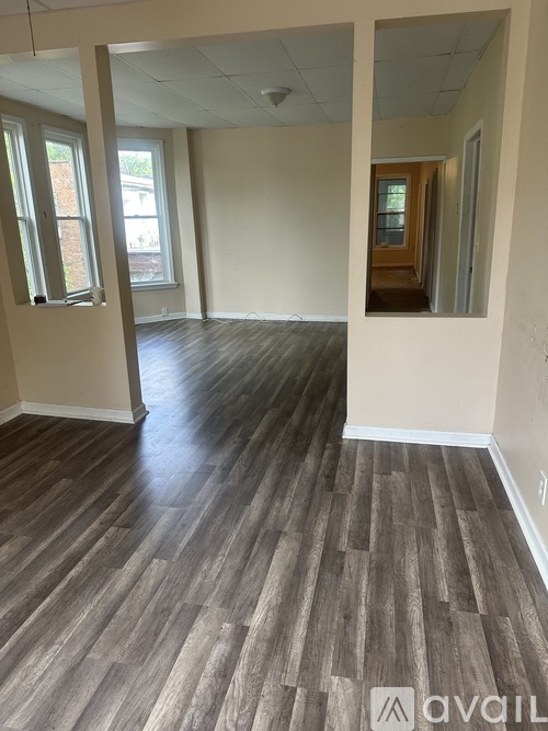 A room with wooden flooring and a window.