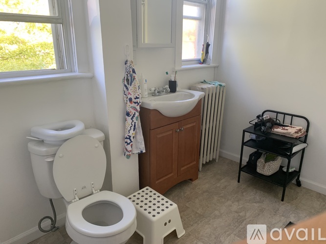A bathroom with a toilet, sink, and a towel rack.