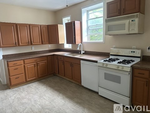 A kitchen with brown cabinets and a white stove.