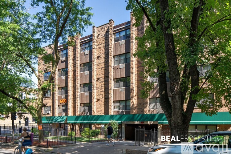 A large brick building with a green awning and the words "Beal Properties" on it.